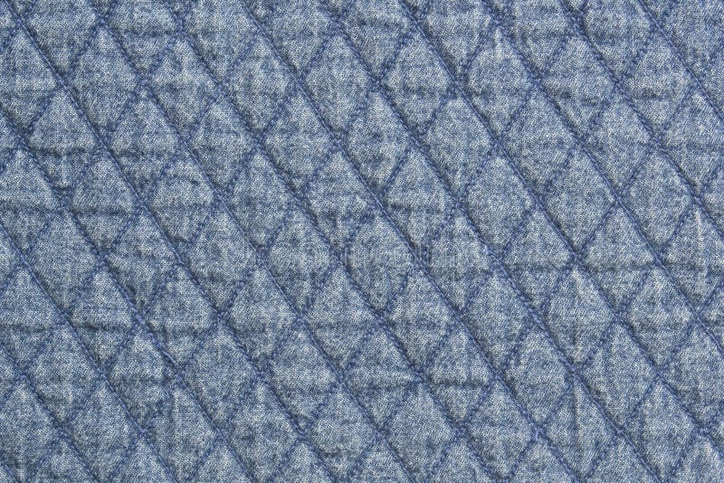 Quilted fabric blue denim cloth element texture close up. Quilted fabric blue denim cloth element texture close up